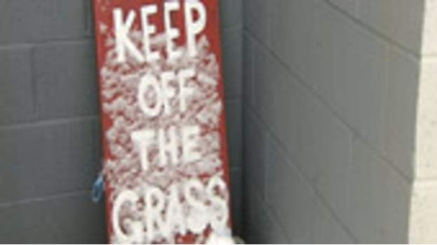 Snow sign saying 'Keep off the Grass'