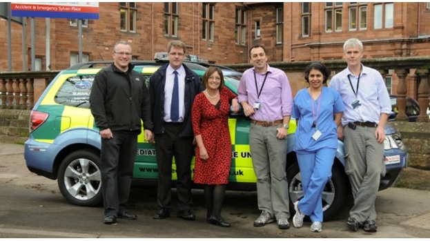 Maureen Harrison (centre) unveiling a new vehicle the charity helped purchase